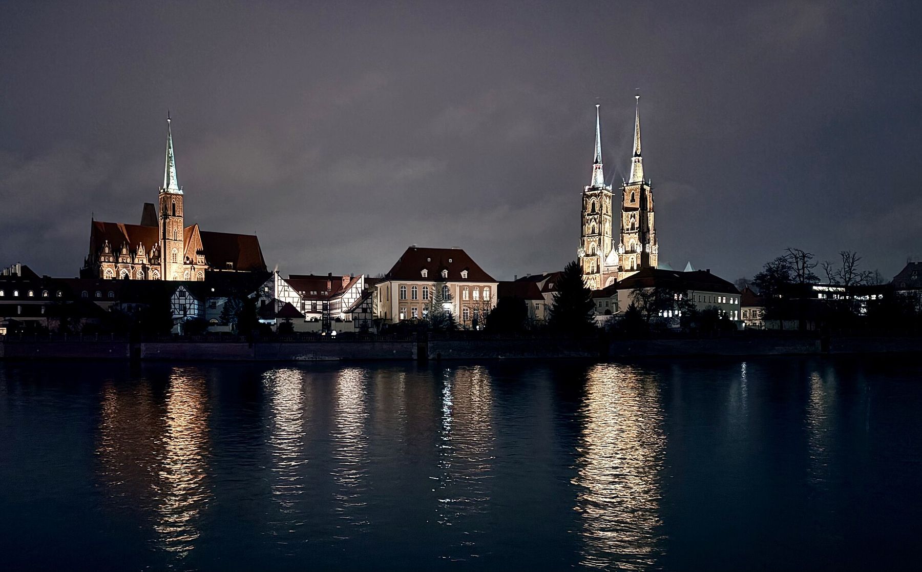Ostrów Tumski we Wrocławiu nocą, widok przez Odrę